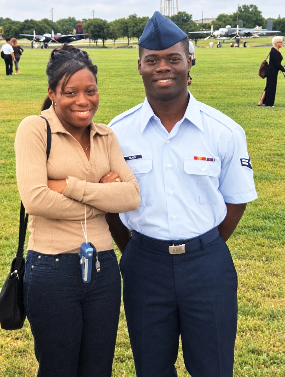 Chief Seals as a young Airman in service dress with his wife Charidy, outdoors on base.