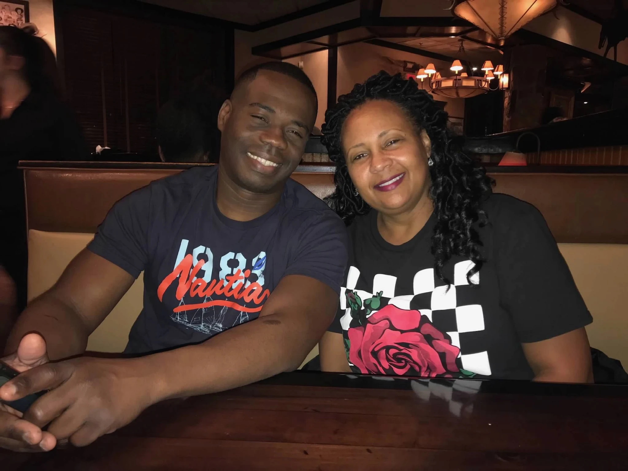 Chief Seals and his wife at a restaurant table, a rose on the table in front of them.