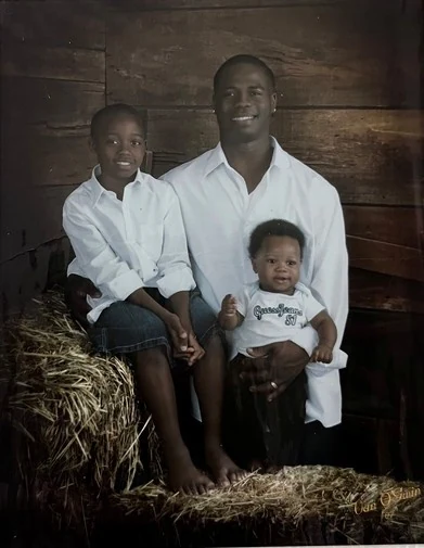 Chief Seals with his sons, a studio portrait on a hay bale.